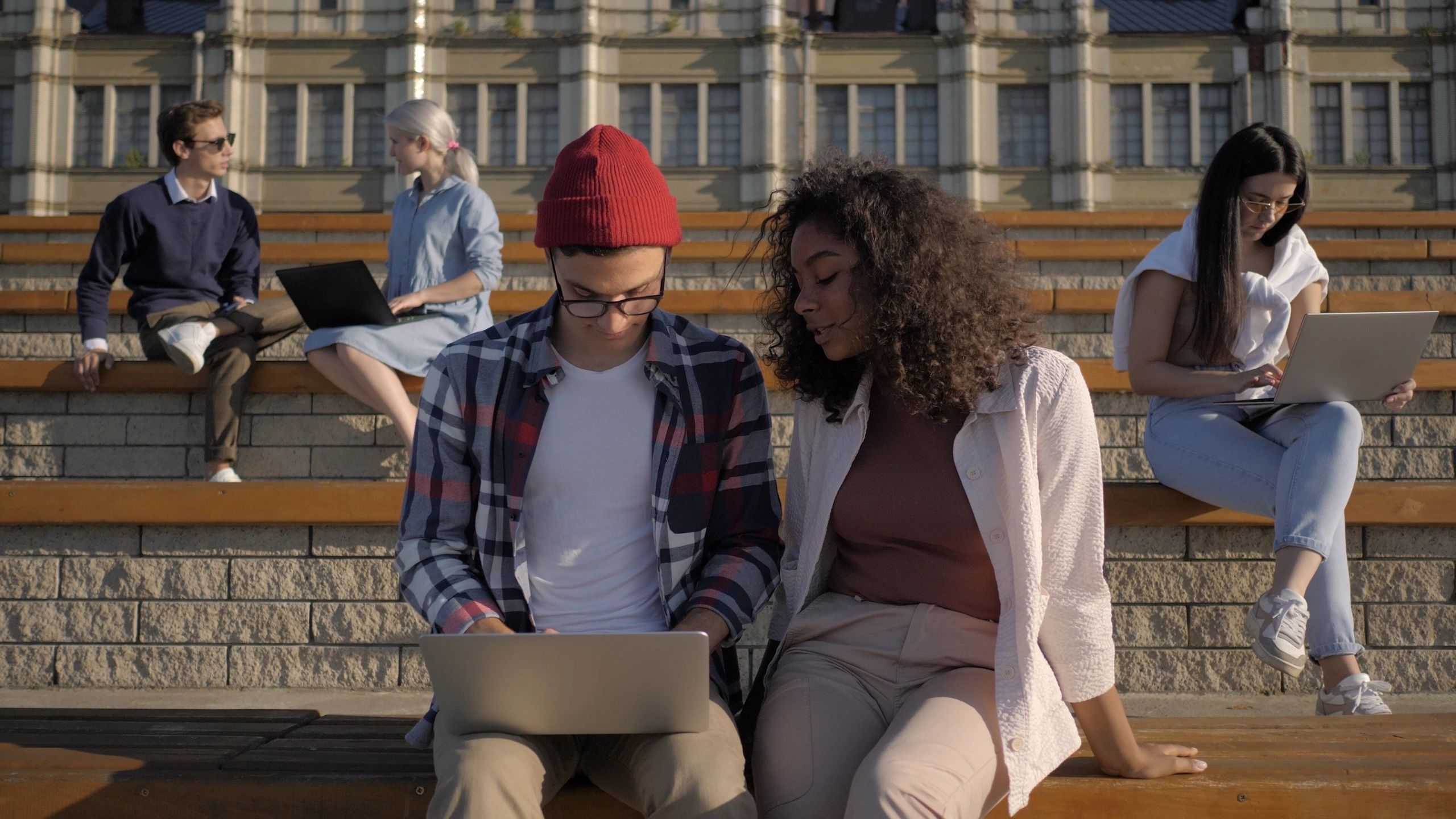 People working on laptops outdoors