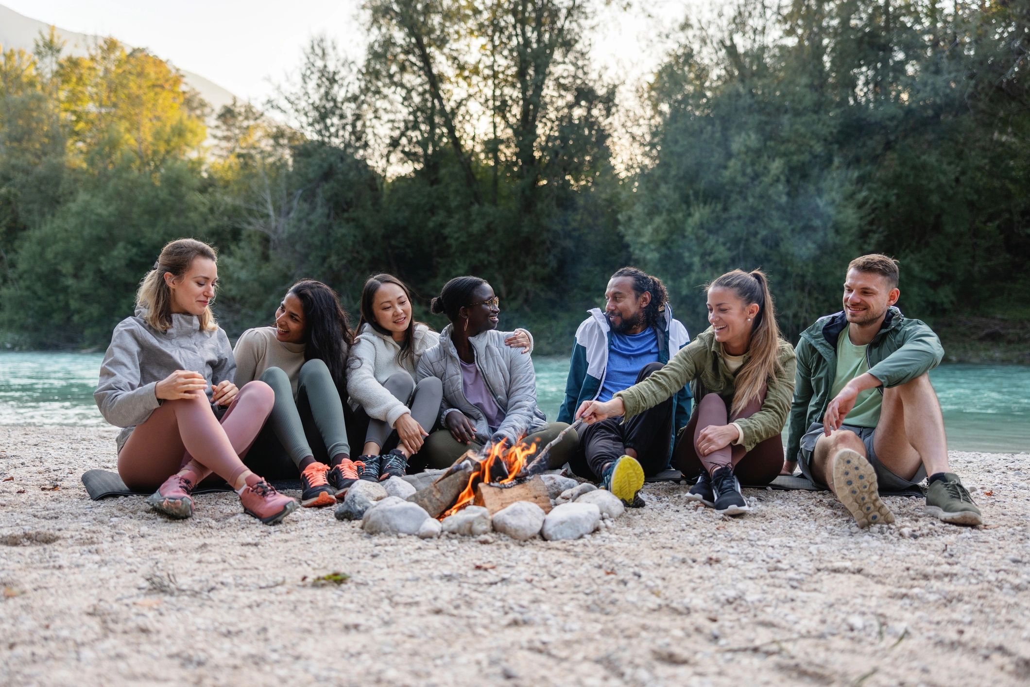 Friends gathered outdoors by a campfire