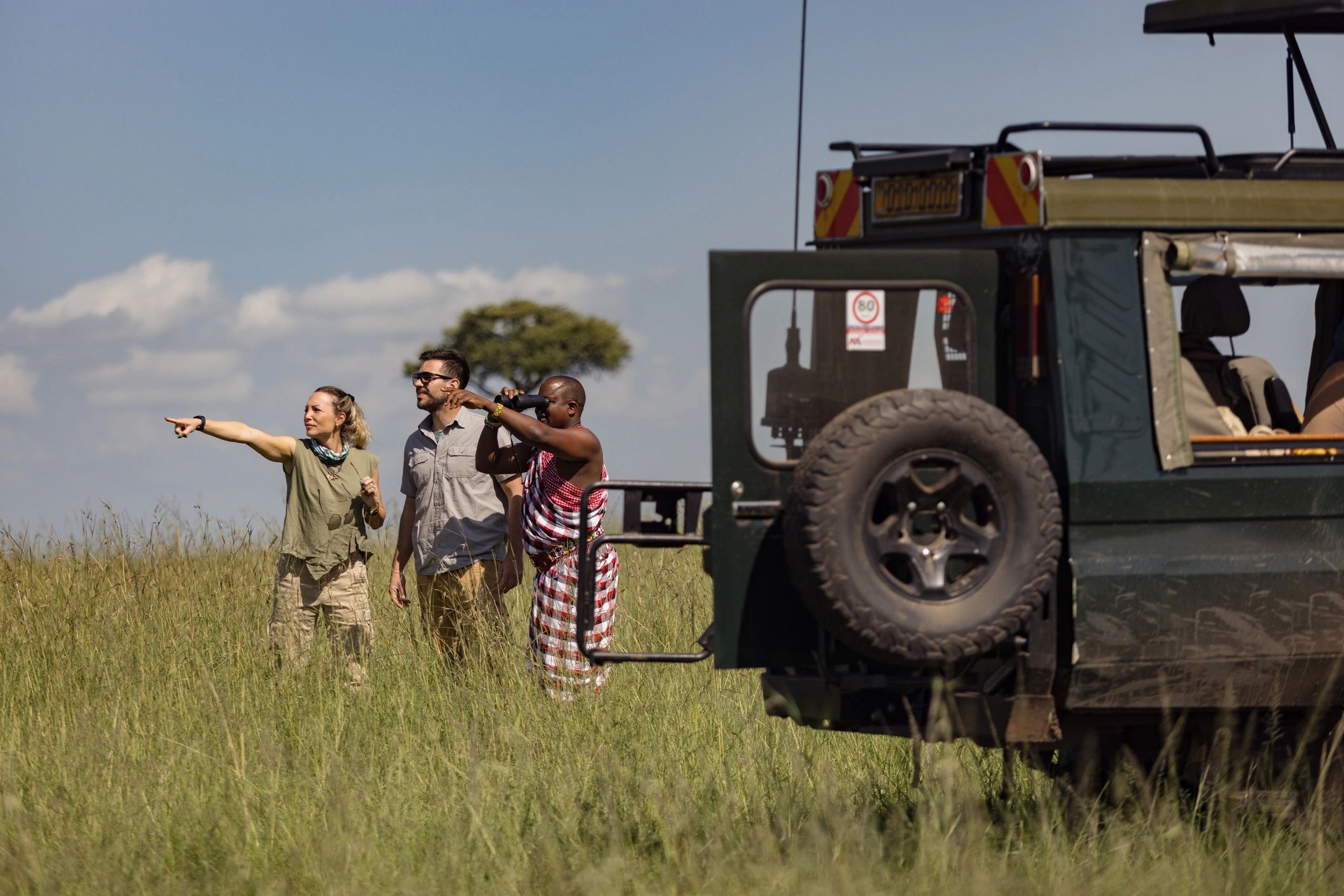 Travelers and local guide in African landscape