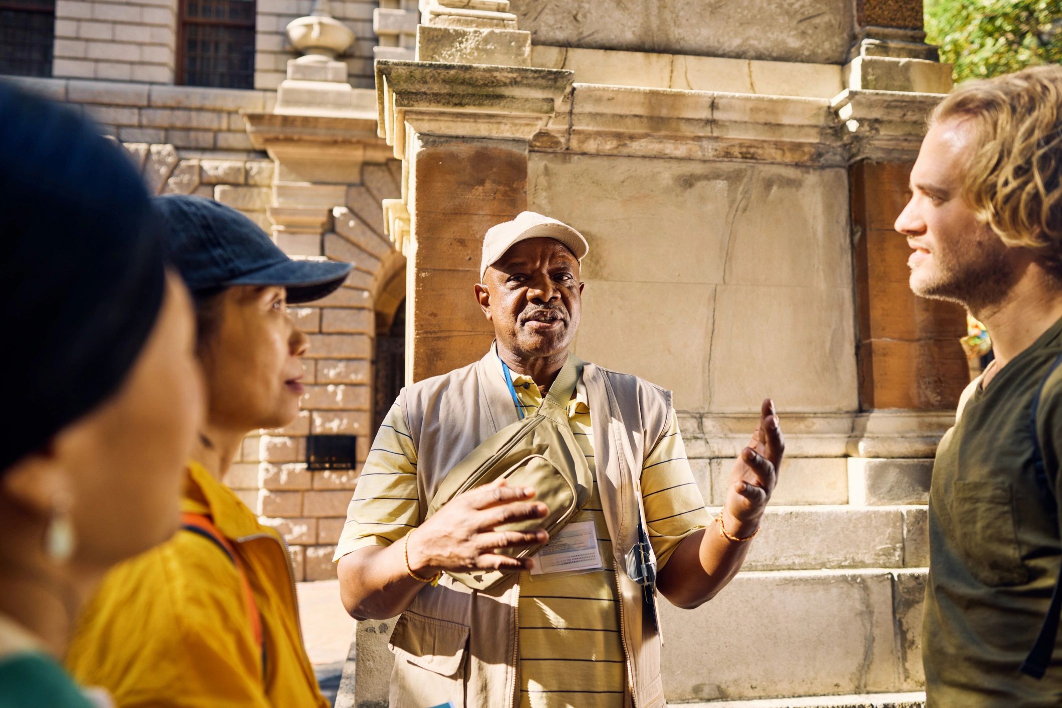 Group of travellers listening to a guide during an urban cultural tour