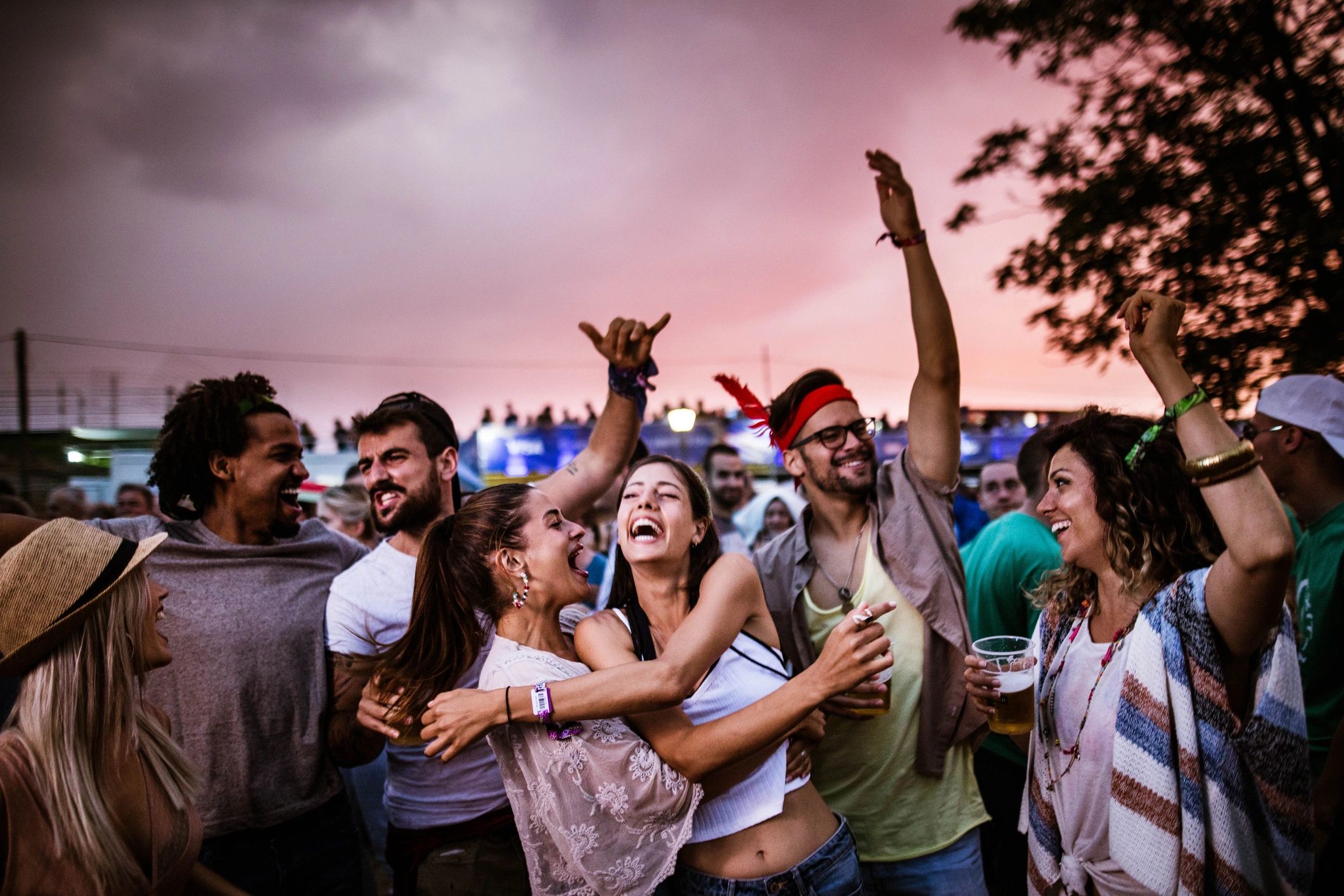 Large group of cheerful friends dancing on an outdoor party
